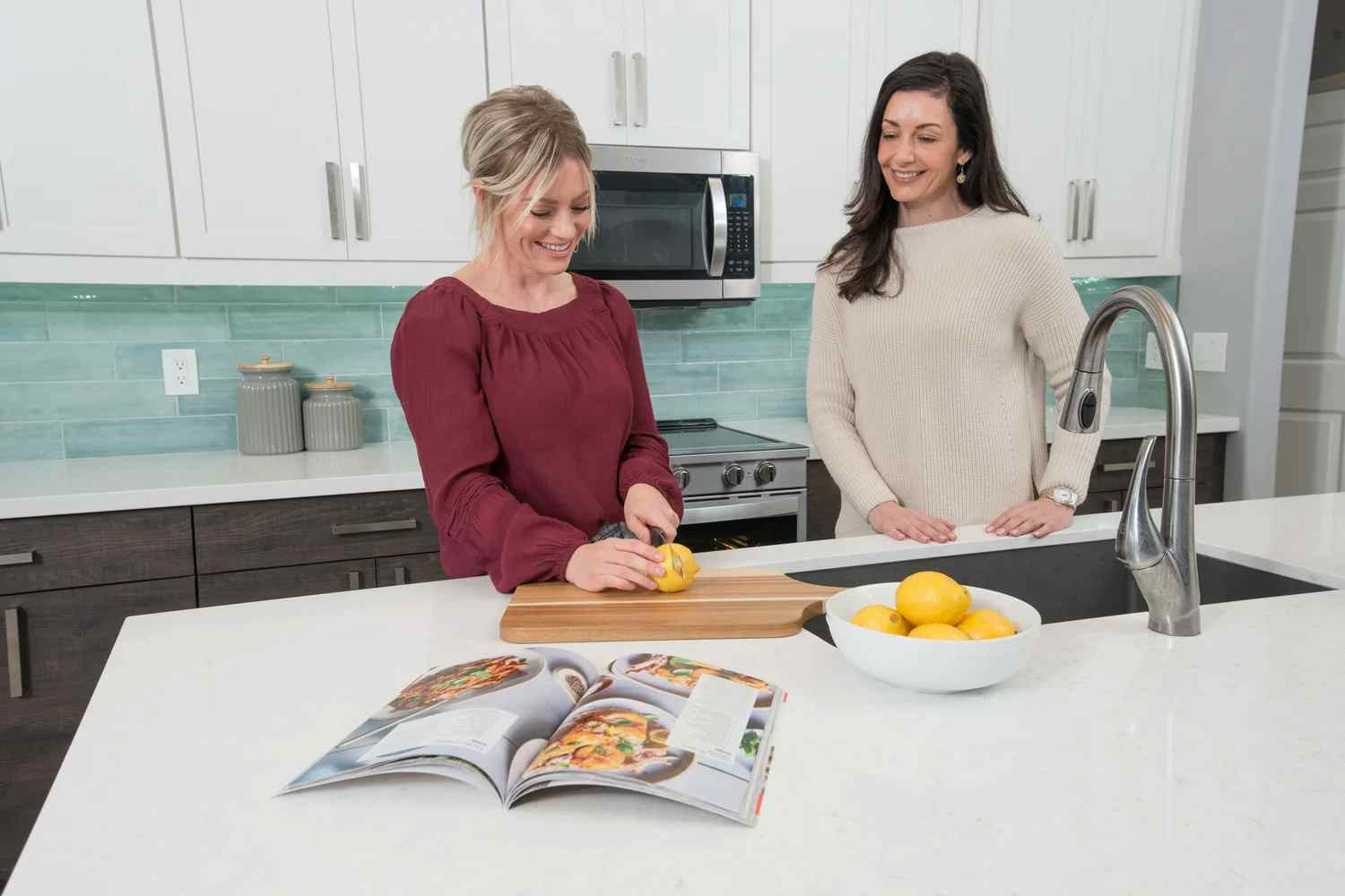 2 people cutting lemons on kitchen island with storage built by Classy Closets