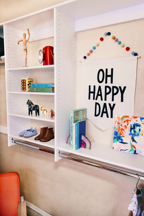 kid closet storage area with 'oh happy day' poster